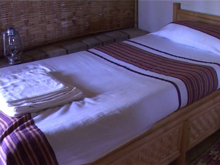 Bedroom with handwoven textiles and a lantern